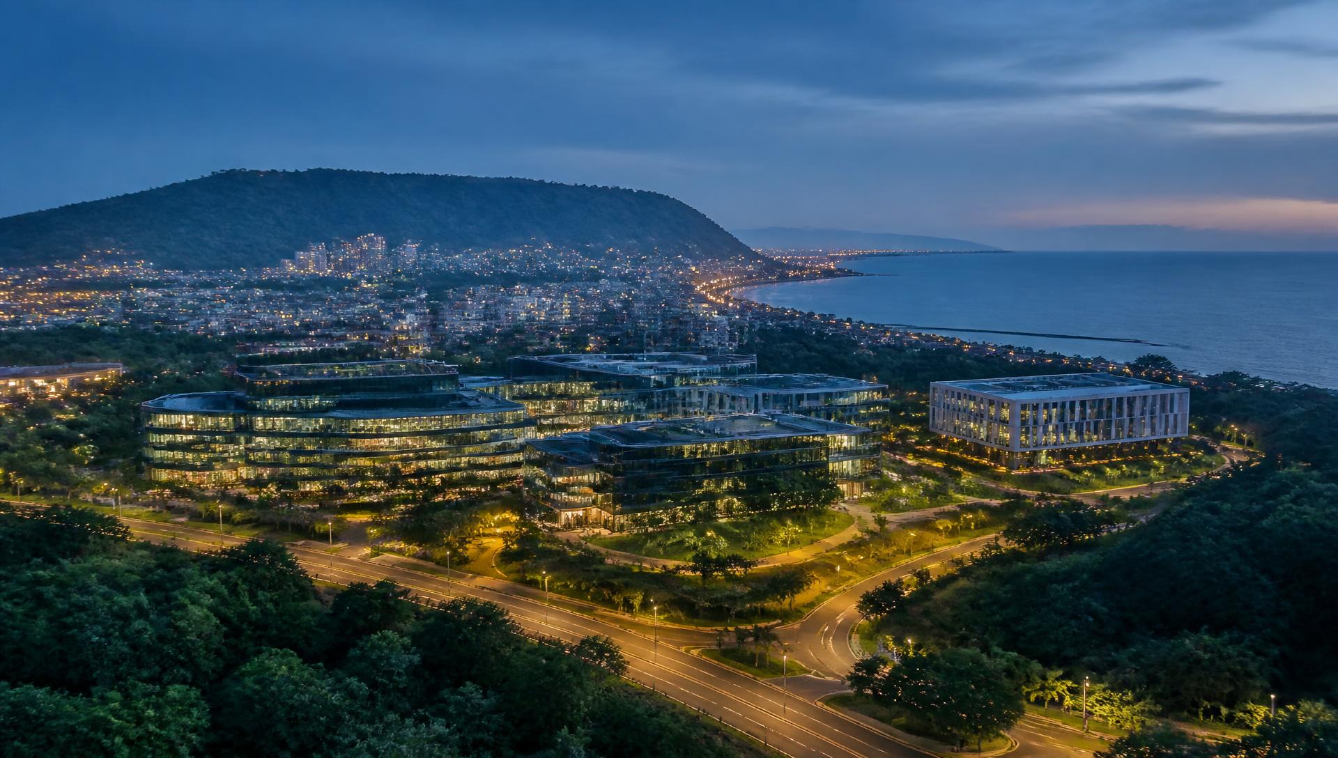 Dusk over Visakhapatnam, with green hills, a technology campus and the sea beyond